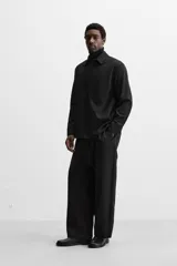 Camisa color crema de corte regular fit, confeccionada en tejido con viscosa. Tiene cuello solapa, manga larga con puños abotonados, bolsillo de parche en el pecho y cierre frontal con botones.