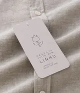 Camisa celeste de lino con cuello camisero, abotonadura frontal y mangas largas.