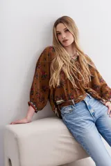 Camisa marrón con estampado floral y lentejuelas, escote en V y mangas largas abullonadas.