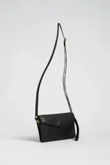 Bandolera negra de cuero sintético con solapa y correa larga ajustable.
