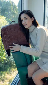 Mochila agamuzada color marrón claro con detalle tramado al frente. Apertura superior con cierre metálico, división al medio y bolsillos internos. Incluye correa corta de mano y correas regulables para colgar en la espalda.