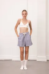 Short a rayas verticales azules y blancas de algodón, con cintura elástica y cordón ajustable. Incluye musculosa blanca de rib de regalo.