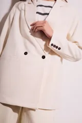 Blazer color crema de poliéster y viscosa, de corte oversize con solapas y doble botonadura.