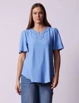 Blusa celeste de tejido piqué, con cuello a la base y escote en V. Tiene mangas cortas amplias.