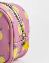 Cartuchera rectangular de poliuretano color lila con estampado de limones amarillos. Tiene cierre superior con cremallera y tirador metálico.