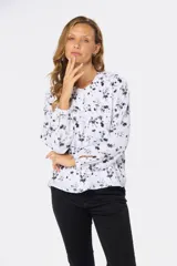 Blusa blanca estampada con hojas en color azul, de manga larga abullonada y cuello redondo.