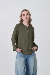 Blusa de poliéster color verde oliva, de manga larga y corte holgado, con escote en V y tapeta de botones.