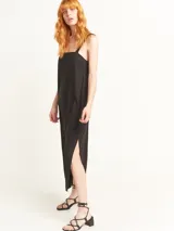 Vestido largo color negro, holgado, con escote cuadrado y breteles trenzados, y tajos laterales.
