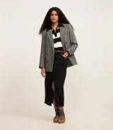 Falda midi de jeans color negro, de corte recto, con bolsillos delanteros y traseros, abertura frontal y cierre con botón y cremallera.