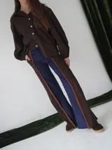 Pantalón de paño combinado con tira de cuero color naranja en los laterales.