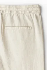Pantalón de lino color crema, con cintura elástica y cordón ajustable.