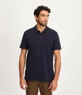 Polo azul marino de corte regular, confeccionada en algodón con textura de rayas horizontales. Tiene cuello inglés, botones en el pecho y mangas cortas.