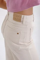 Pantalón de jean color beige, de corte palazzo, con bolsillos delanteros con botón y cintura alta.