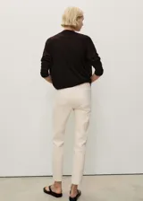 Pantalón de jean color crudo, corte mom fit, tiro alto, cinco bolsillos y cierre con cremallera y botón.