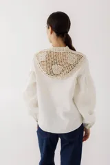 Blusa negra con cuello de crochet hecho a mano, cuerpo de lino y mangas amplias que se ajustan al puño.