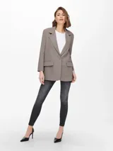 Blazer color visón de corte oversize, con solapas de muesca, cierre de un botón y bolsillos delanteros con solapa.