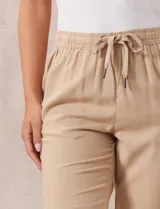 Pantalón liso color beige, marca Dash, con pretina elastizada, bolsillos delanteros y bolsillos traseros simulados.