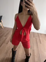 Top rojo con breteles finos, escote en V y detalle de nudo en el centro.