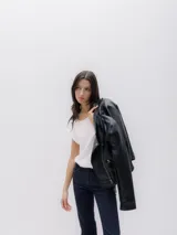 Chaqueta biker negra de cuero sintético con cierre asimétrico, cuello con solapas y tachas plateadas.