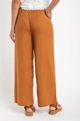 Pantalón de lino color ocre, de corte recto y tiro medio, con lazo de ajuste en la cintura.