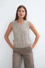 Chaleco tejido marrón con escote en v y sisas amplias. Diseño con diferentes puntos combinados en el frente.