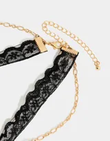 Collar corto con choker de encaje negro, cadena dorada y dije de corazón dorado.