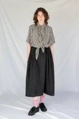 Falda midi negra con cintura elastizada y frunces en los lados.