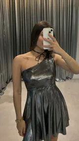 Vestido corto plateado metalizado de fiesta, con un solo hombro y falda acampanada.