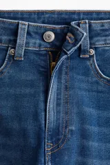 Pantalón de jean de tiro alto con denim levemente elástico, cierre con botón y piernas amplias con bajos acampanados. Cuenta con bolsillos decorativos adelante y bolsillos atrás.