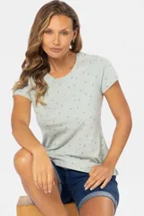 Remera de manga corta color gris claro con estampado de pequeñas figuras geométricas en azul.