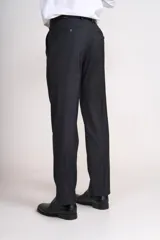 Traje de vestir azul marino, compuesto por saco de dos botones con solapa de muesca, dos bolsillos laterales con solapa y un bolsillo de ojal en el pecho, y pantalón de vestir con corte recto. Incluye camisa blanca, corbata celeste y pañuelo de bolsillo blanco con borde celeste.