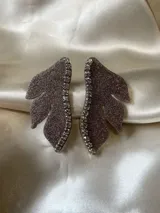 Aro dorado en forma de media flor con detalle de strass.