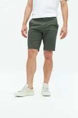 Bermuda de gabardina color verde militar, con bolsillos laterales y traseros, cierre con cremallera y botón, y trabillas para cinturón.