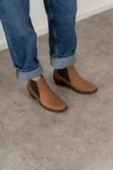 Botín negro de cuero con paneles laterales de gamuza y elástico en los tobillos. Tiene un pequeño taco cuadrado.