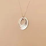 Collar de plata 925 con dije de tres aros entrelazados. El dije tiene tres aros de diferentes tamaños, todos de plata lisa y brillante.
