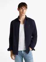Camisa Tommy Hilfiger de manga larga azul marino, corte slim y cuello abotonado. Confeccionada en mezcla de algodón y poliéster.