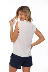 Blusa color crema con escote en V, sin mangas y detalle de encaje en hombros y cuello.