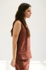 Top sin mangas confeccionado en mezcla de lino y algodón color marrón, con escote en V y pespuntes blancos decorativos en contraste.