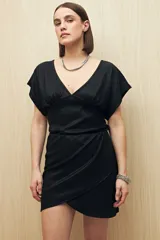 Minivestido negro de tejido texturizado con escote en V, mangas cortas y corte cruzado con drapeado en la cintura.