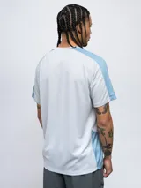 Remera deportiva Umbro de manga corta, color azul marino con paneles laterales y en las mangas de tela texturizada en tono azul más claro. Cuello redondo y logo Umbro bordado en el pecho.