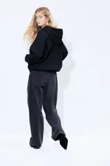 Campera negra con capucha y cierre frontal, con bolsillo tipo canguro y estampado blanco con la inscripción 'Seine Paris'.