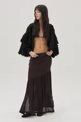 Cárdigan de tejido de punto negro con lurex de colores, detalles calados, trenzas tejidas y flecos en mangas y espalda.