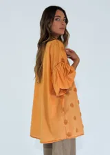 Camisa color lila con textura de lunares en relieve, de corte holgado, manga 3/4 con volados y cierre frontal con botones.