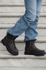 Botas cortas de cuero color gris gastado, con suela track y detalle de hebilla en la caña.
