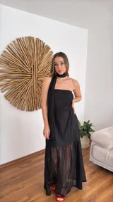 Vestido largo negro de tejido de punto con escote recto y breteles finos. La falda es de encaje transparente. Incluye una bufanda fina al tono.