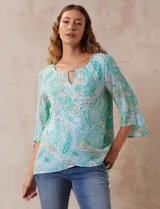 Blusa de gasa estampada marca Ruby Rd. con cuello redondo, escote en V con aplique metálico, delantera con sobre capa y terminación asimétrica. Manga ¾ amplia.
