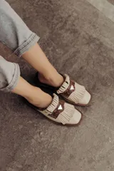 Zueco de cuero color crudo con detalle de flecos y pieza central en cuero snake.