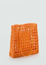Bolso shopper naranja de fibra natural con diseño calado y doble asa fina.
