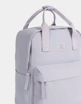Mochila negra de tela deportiva con correas regulables, manijas superiores con broche, acceso con cierre superior y puller de cuerina, bolsillo frontal con cierre y puller de cuerina, y tag de goma.