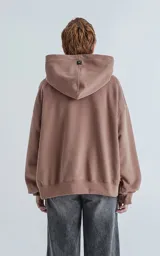 Hoodie marrón confeccionado en frisa gamuzada 100% algodón, de calce oversize crop. Tiene bolsillo canguro y capucha forrada.